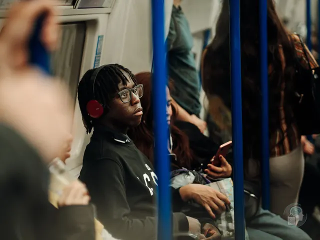 Joven con cascos en un vagón de metro abarrotado, una forma habitual de protegerse del ruido en el autismo adulto