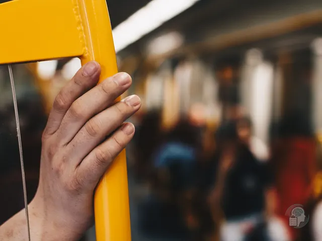 Mano agarrada con fuerza a la barra de un vagón de metro lleno de gente durante un ataque de pánico
