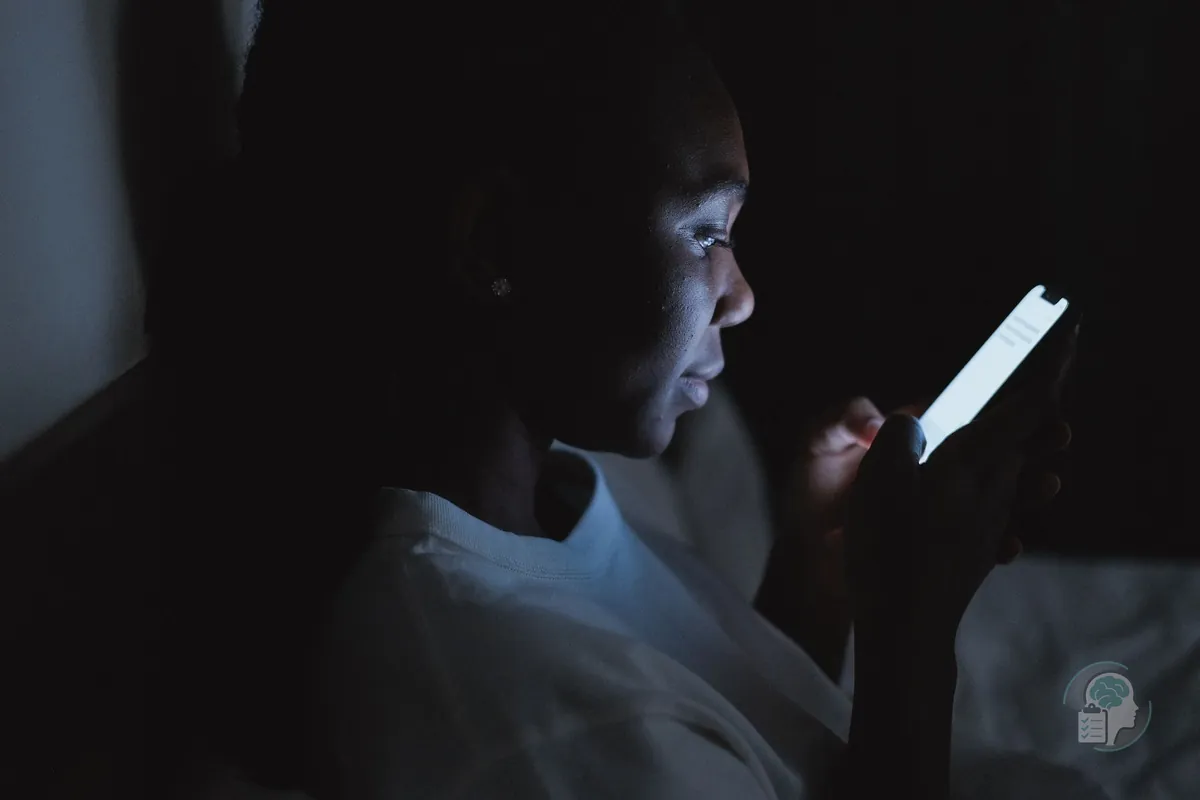 Mujer leyendo información sobre síntomas en el móvil a oscuras de madrugada