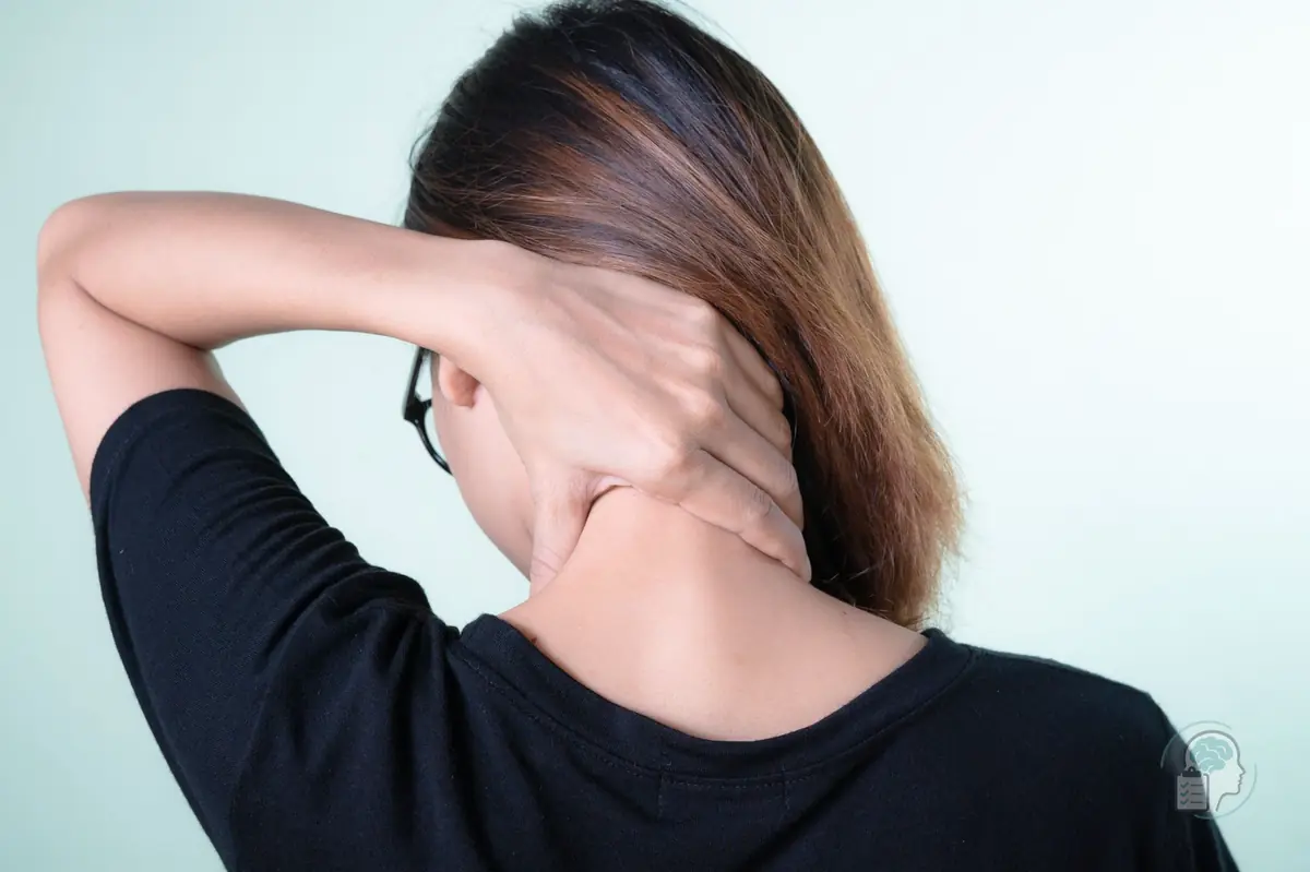 Mujer de espaldas que se masajea la nuca con la mano, una zona que suele notarse tensa y sensible en la cefalea tensional