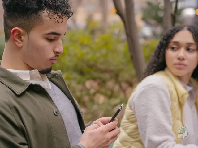 Mujer mirando con recelo a su pareja mientras él escribe en el móvil, una escena típica de los celos en la pareja