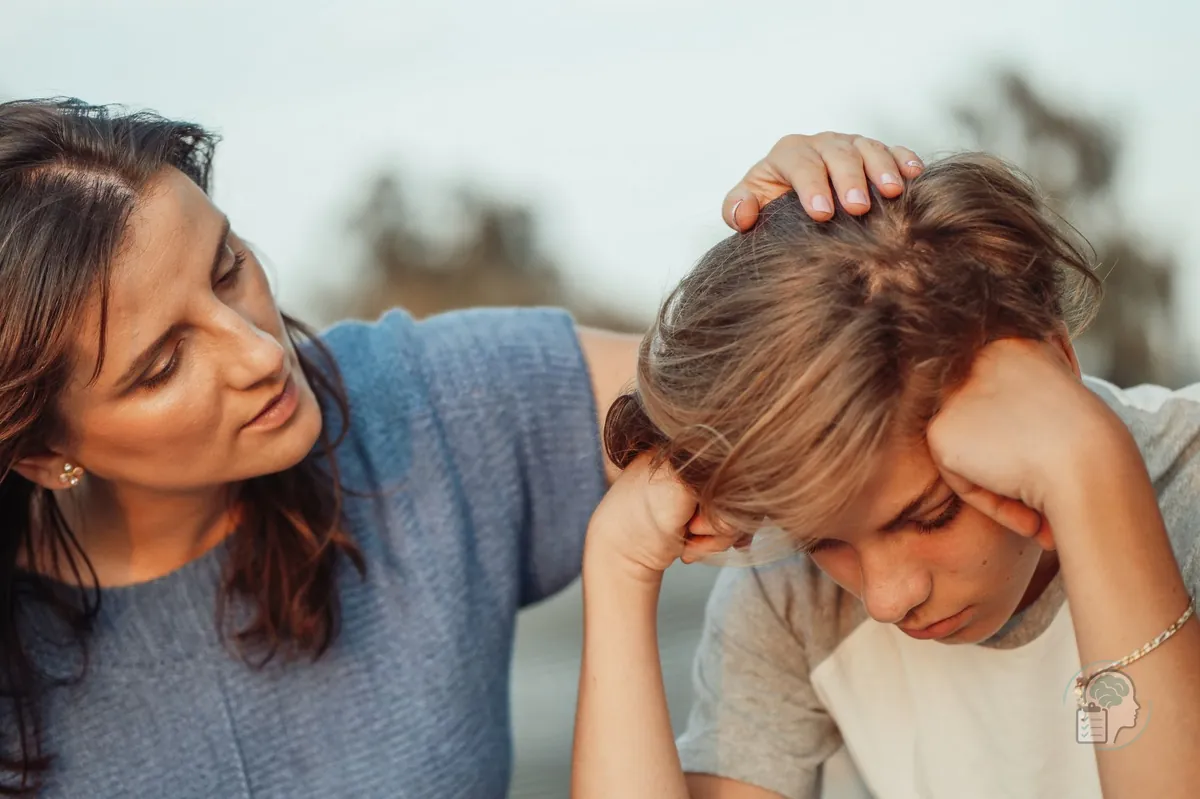 Madre consolando a su hijo adolescente preocupado, un momento en que muchos padres se preguntan si llevarlo al psicólogo