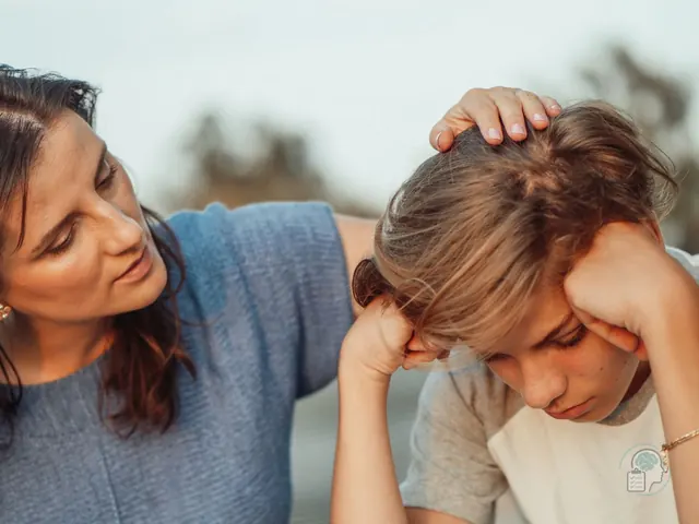 Madre consolando a su hijo adolescente preocupado, un momento en que muchos padres se preguntan si llevarlo al psicólogo