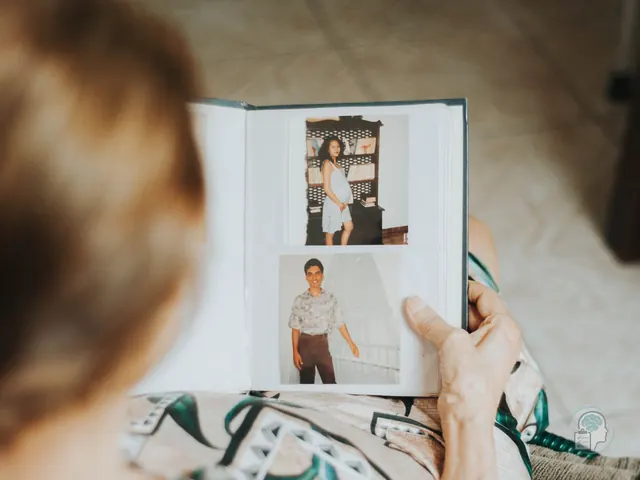 Persona mayor mirando un álbum de fotografías familiares antiguas durante el duelo por un ser querido