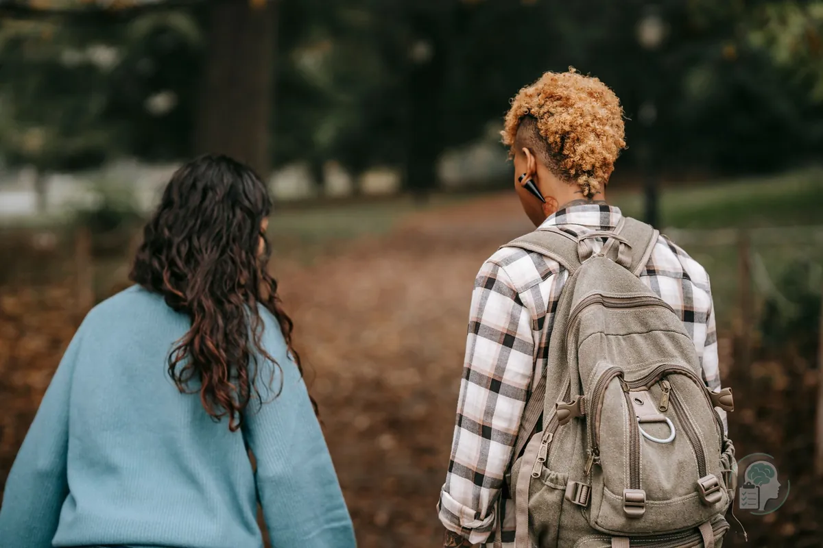 Dos amigas caminando juntas por un parque, una forma más fácil de hablar de temas difíciles