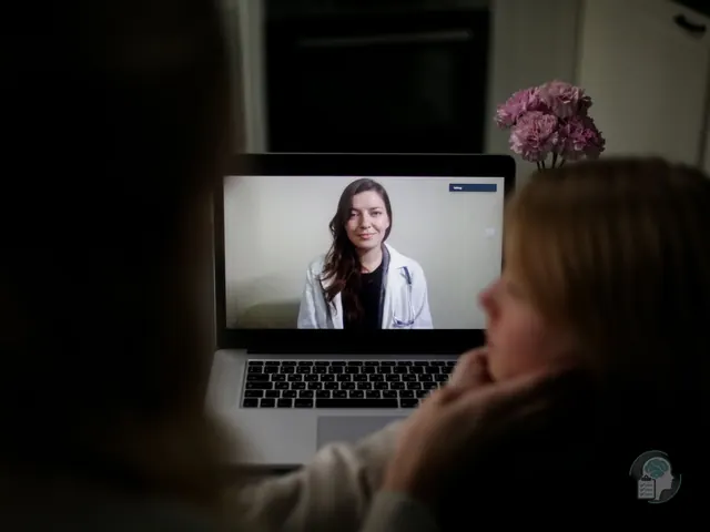 Mujer en una sesión de terapia con su psicóloga online, visible en la pantalla del portátil durante la videollamada