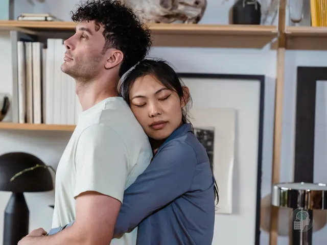 Mujer abrazada con fuerza a la espalda de su pareja, que mira hacia otro lado, una imagen de la dependencia emocional