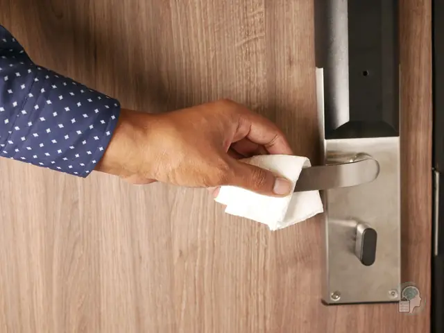 Mano que abre una puerta sujetando la manilla con un pañuelo de papel para no tocarla, un gesto habitual en el TOC de contaminación