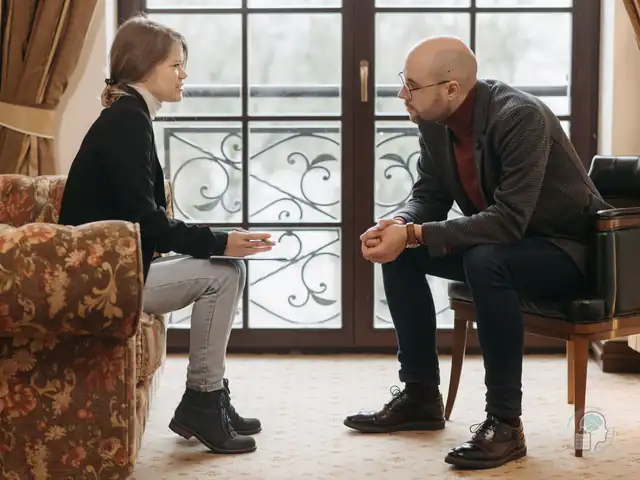 Sesión de terapia en la que una psicóloga y un paciente conversan sentados frente a frente, una imagen del tratamiento psicológico del trastorno bipolar
