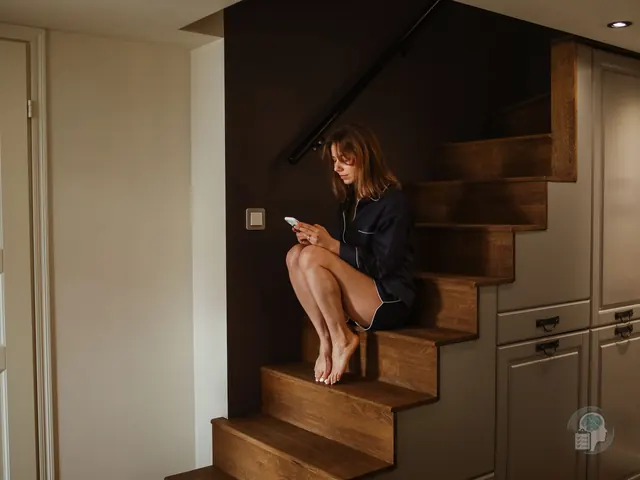Mujer sentada sola en las escaleras de casa mirando el móvil después de una ruptura de pareja