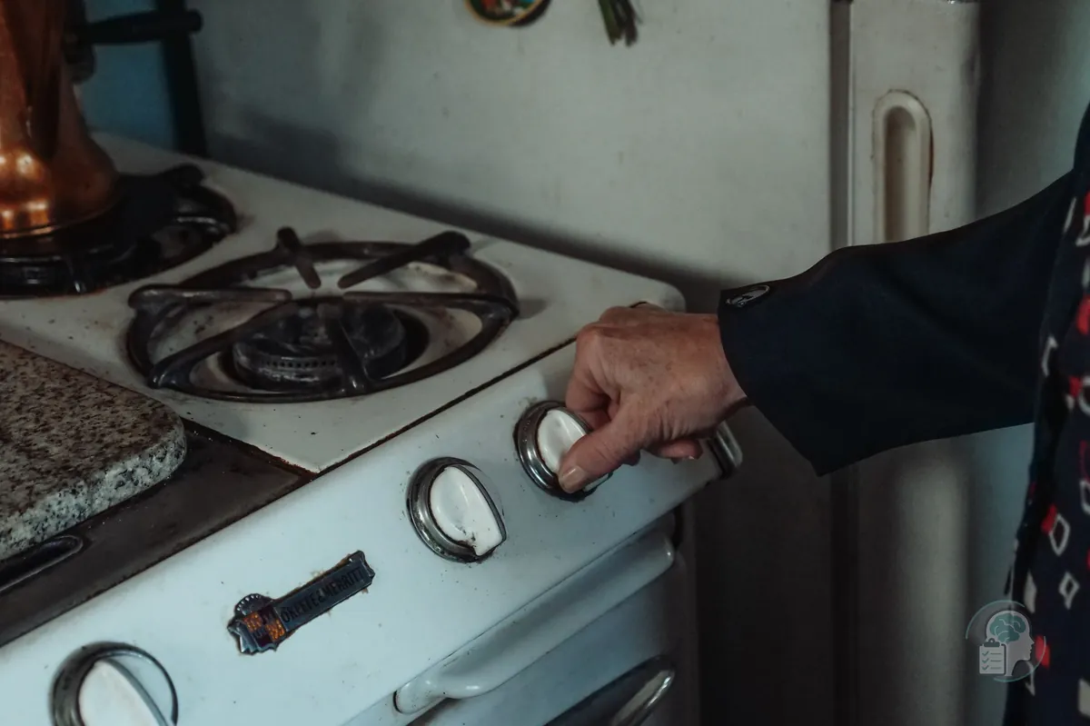 Mano que gira el mando de una cocina de gas, una de las comprobaciones más típicas del TOC de comprobación