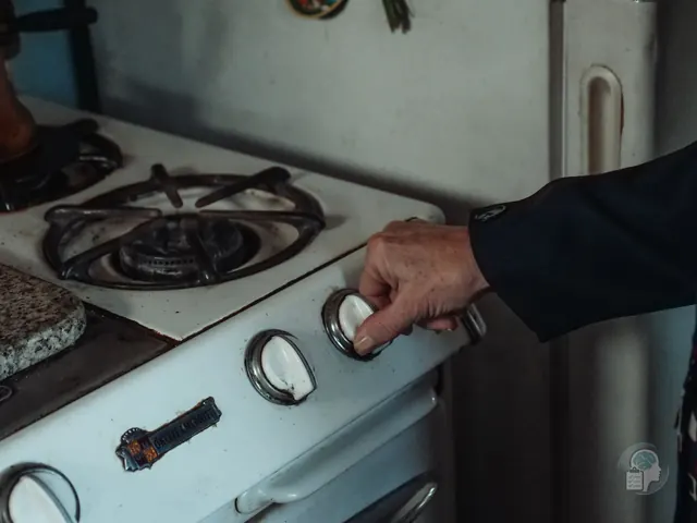 Mano que gira el mando de una cocina de gas, una de las comprobaciones más típicas del TOC de comprobación