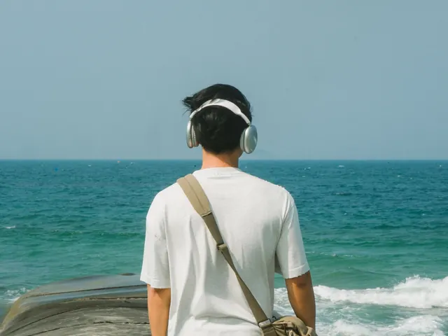 Joven con auriculares mirando el mar en calma, en busca de un entorno tranquilo; imagen del test de autismo en adultos