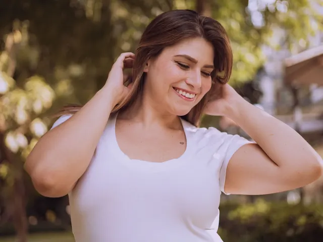 Mujer sonriendo al aire libre con las manos en el pelo, ilustrando la confianza y el bienestar que mide el test de autoestima