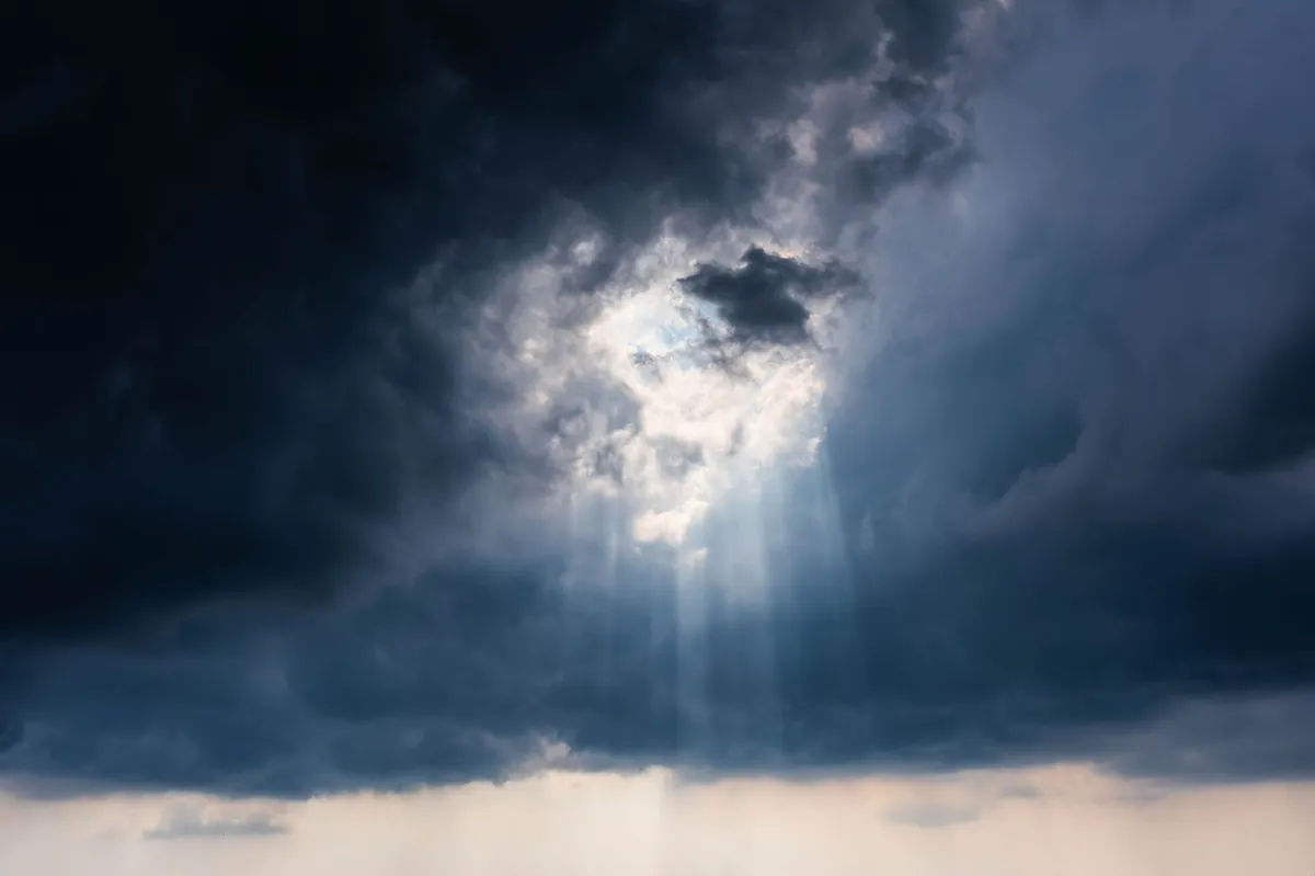 Cielo de tormenta con rayos de sol abriéndose entre las nubes, imagen de cabecera del test de trastorno bipolar